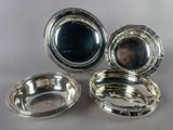 three silverplated dishes on a table with a mirror in the background