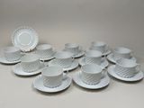 a lot of cups and saucers sitting on a table