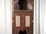 une photo d'une grande armoire en bois dont les portes sont ornées de sculptures raffinées