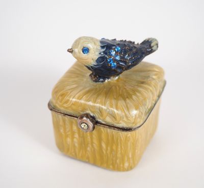 a small blue bird sitting on top of a yellow box