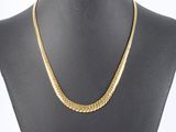 a gold chain necklace on a mannequin torso