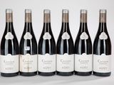 six bouteilles de vin sont alignées sur une table