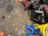a pile of tools on the ground next to a trash can