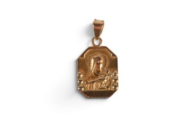 a gold plated pendant with an image of the virgin and child