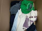 a cardboard box filled with clothes and a t - shirt