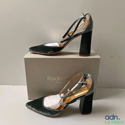 Les chaussures noires et dorées sont posées sur une boîte