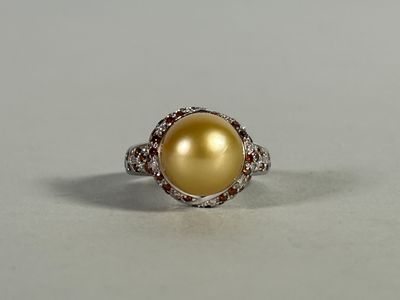 yellow pearl and diamond ring on a white surface