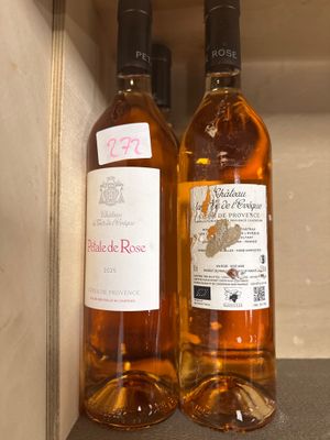 deux bouteilles de vin posées sur une étagère l'une à côté de l'autre