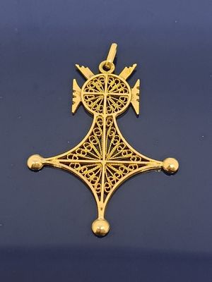 gros plan d'une croix en or sur une surface noire