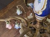 a chandelier that has a blue and white vase on top of it