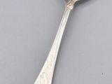 a close up of a spoon on a table with a gray background