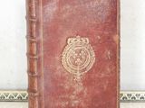 a brown book with a crest on it sitting on a table