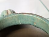 a close up of a green bowl with a ball on it