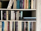 a book shelf with many books on it in a room