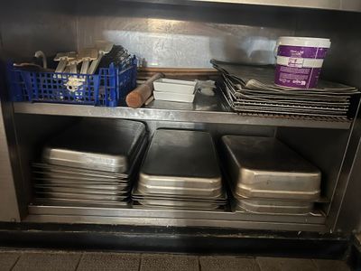 de nombreux plateaux et plats sur l'étagère de la cuisine