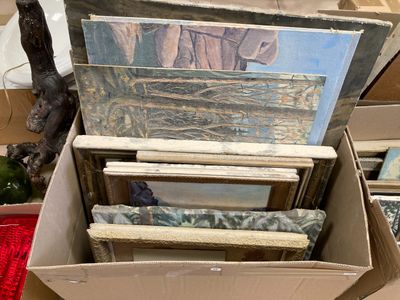 beaucoup de tableaux dans une boîte posée par terre