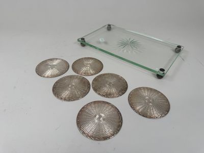 six silver seashells and a glass tray on a white surface
