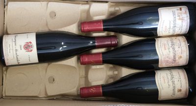 four bottles of wine in a cardboard box on a table