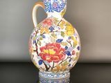 a vase with a floral design on it sitting on a table