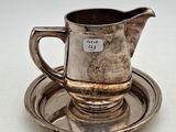 un plateau en argent ancien sur lequel sont posés une tasse et une soucoupe