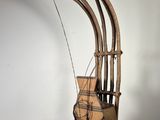 une sculpture en bois représentant un instrument de musique posée sur un socle blanc