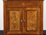 une vieille armoire en bois à deux portes, surmontée d'un tiroir