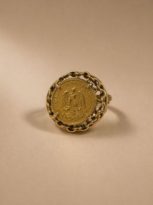 a gold ring with a coin in the middle of it