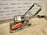 a close up of a small machine on the ground in front of a wall