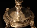 a silver plate with a candle on top of it