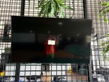 un écran de télévision sur lequel on voit une personne tenant une pancarte
