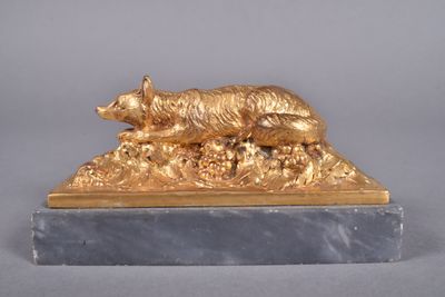 statue d'un chien doré posée sur un socle en marbre, sur fond gris