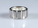 a close up of a ring with diamonds on a white surface