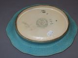 a blue and white bowl on a table with a tag on it