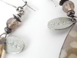 a picture of a pair of earrings that are on a white surface