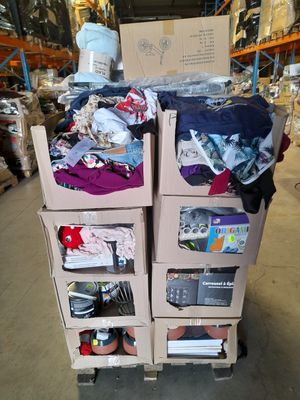 des cartons empilés les uns sur les autres dans un entrepôt rempli de vêtements