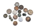 some old coins are scattered together on a white surface
