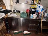 a dirty kitchen with a lot of clutter on the floor