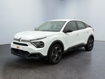 a white car is parked in a room with a black floor
