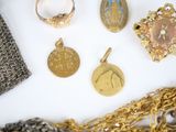 a lot of gold jewelry on a white surface