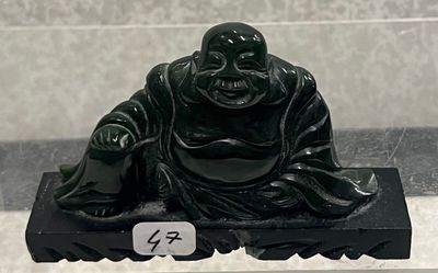une statue noire représentant un Bouddha assis sur un socle noir