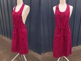 pair of red aprons on mannequins in front of a blue wall