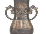 a metal vase with a handle that has a design on it