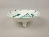 a small white bowl with a green design on it