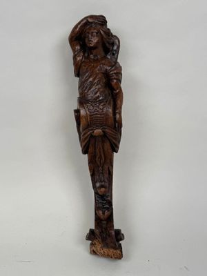 une statue en bois d'une femme avec un chapeau sur la tête