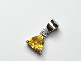 un gros plan d'un pendentif en diamant jaune posé sur une surface blanche
