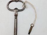 an old key with a keychain attached to it on a white surface