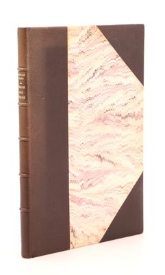 an old book with a brown cover sitting on top of a white surface