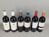 six bottles of wine are lined up in a row on a gray surface
