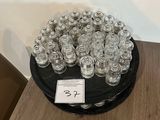 bottles of water sit on a table in front of a wall of wood slices