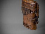 carved wooden head of a man with a mustache and moustache